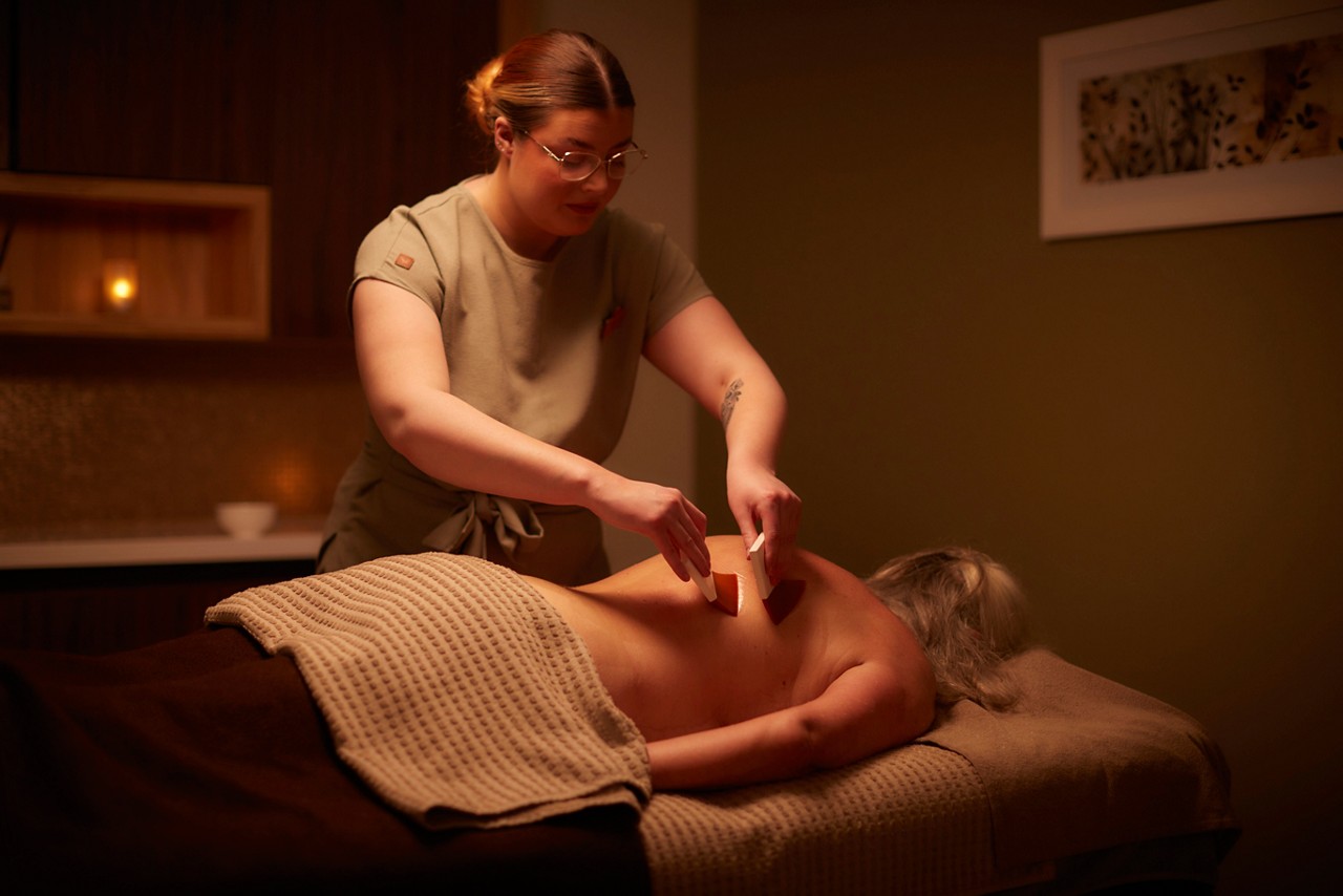 Spa therapist giving a women a relaxing face and body treatment.